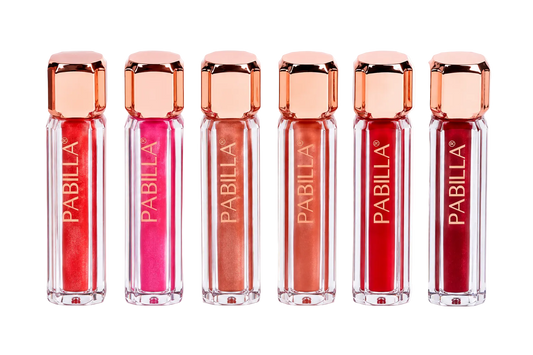 Six Pabilla lip gloss tubes in a row, showing shades of pink, red, and orange, with rose gold caps on a white background.